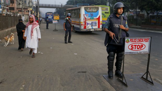 Bangladeshi policemen stand guard on a road during a nationwide strike called by the Jamaat-e-Islami in response to the  executions.