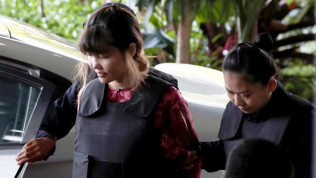Vietnamese Doan Thi Huong, left, is escorted by police as she arrives in court in Kuala Lumpur.