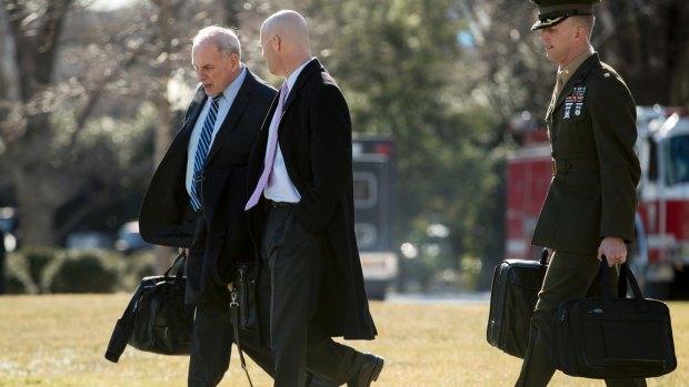 White House Chief of Staff John Kelly, left, and Director of Legislative Affairs Marc Short, centre, prepare to join Donald Turmp aboard Marine One for Camp David.