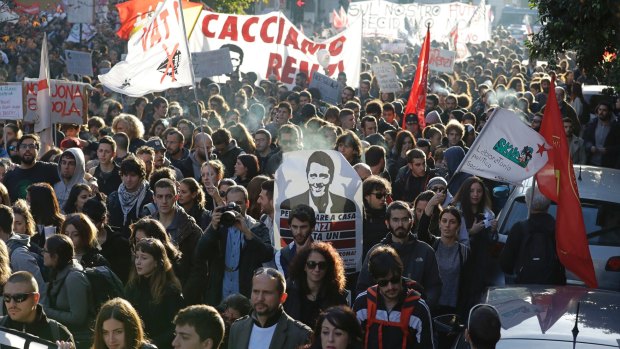 People march behind a banner portraying Italian premier Matteo Renzi that reads "Let's oust Renzi" during a demonstration against the referendum changes.