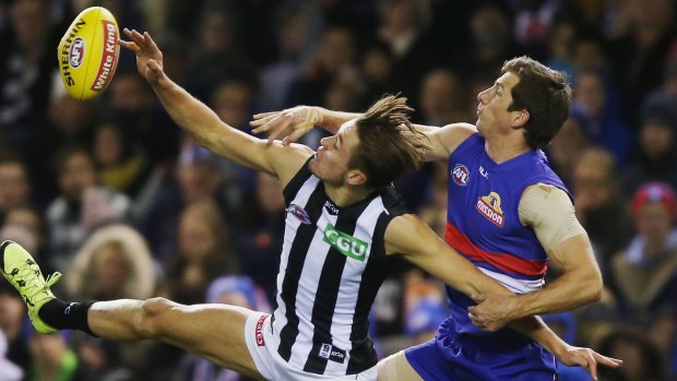 Darcy Moore competes for the ball against Dale Morris of the Bulldogs.