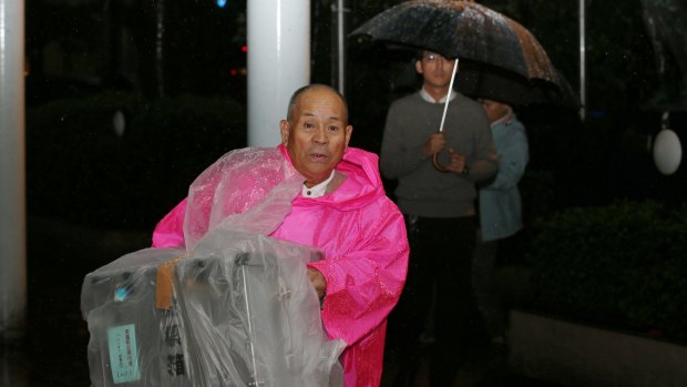An electoral official transports a ballot box for the general election in the rain in Himeji, Hyogo, Japan, on Sunday.