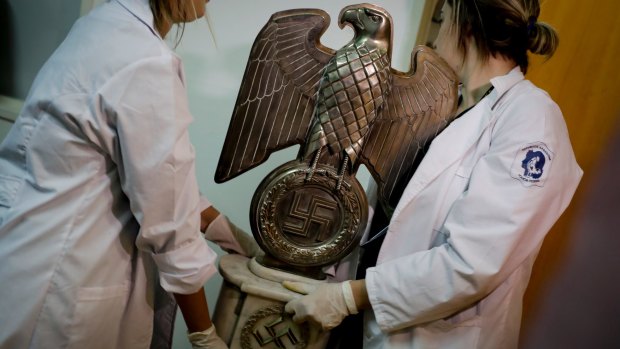 Members of Argentinian federal police carry a Nazi statue found hidden in a house in Buenos Aires.