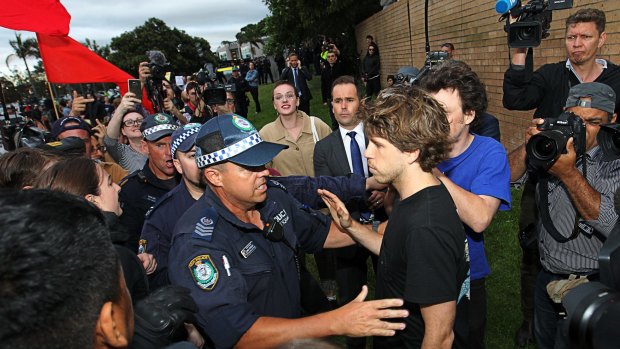 A supporter of Milo Yiannopoulos is escorted by police during clashes with protesters.