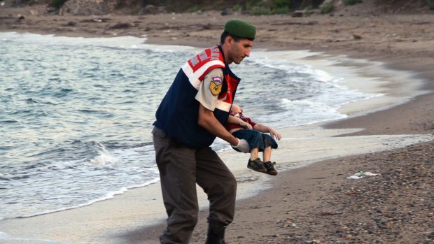 A Turkish paramilitary police officer carries the body of Aylan Kurdi in September.