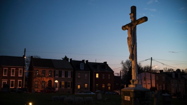 A crucifix stands in the Old St Joseph's Cemetery, near the home  prepared for the arrival of a Syrian refugee family in Lancaster,  Pennsylvania.