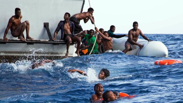 Migrants from a sinking inflatable dinghy board a Libyan coast guard ship during a rescue operation at sea in international waters off the coast of Libya last week.