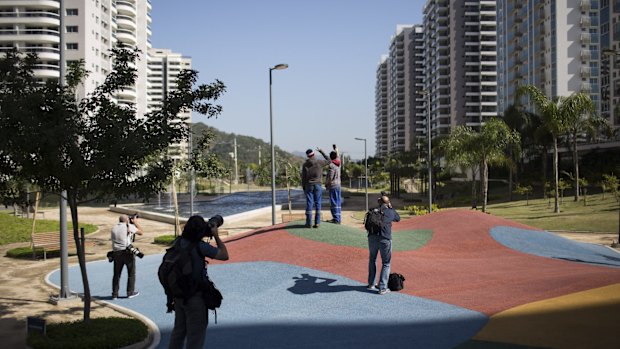 Journalists and workers take photos before the opening ceremony of the Olympic Village in Rio on Wednesday.