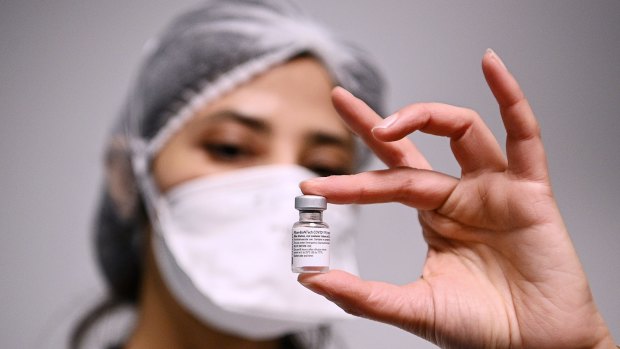 A health worker displays a dose of the Pfizer-BioNTech COVID-19 vaccine at Robert Ballanger Hospital in Paris.