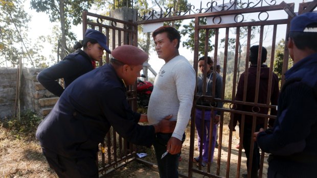 A Nepalese policeman checks a man for weapons during the legislative elections in Chautara, Nepal, on Sunday.
