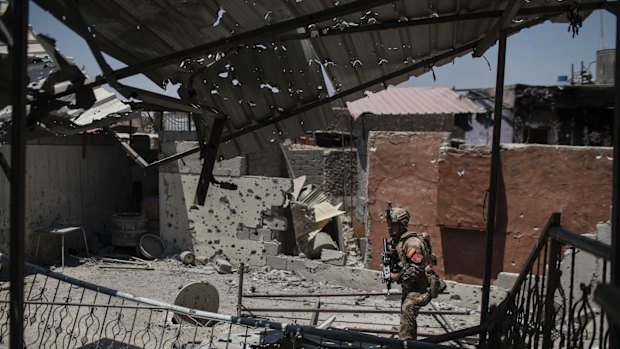 An Iraqi soldier walks by a damaged house during fighting against Islamic State militants in the Old City of Mosul on Tuesday.