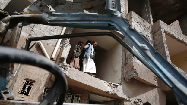 Yemeni people inspect a house damaged by a Saudi air strike in Sanaa, Yemen, last August.