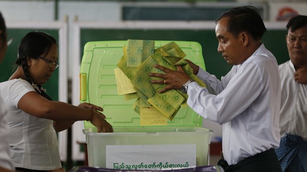 Union Election Commission officials sort ballots at a polling station in Mandalay.