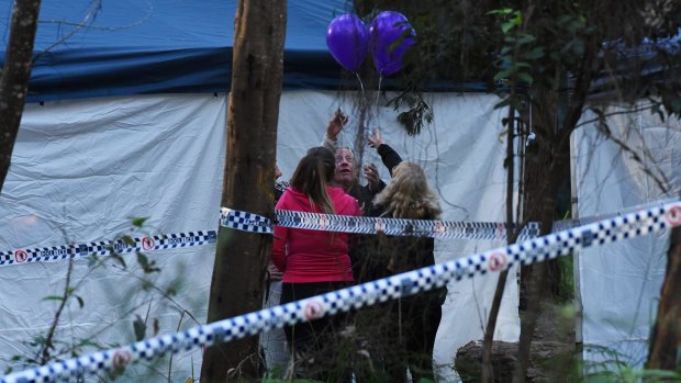 Mark Leveson (second from right) and Faye Leveson (right) release balloons with friends at the crime scene.