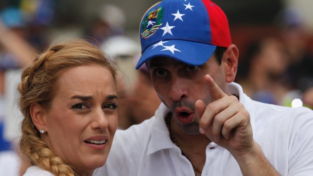 Lilian Tintori, wife of jailed opposition leader Leopoldo Lopez, left, and opposition leader Henrique Capriles, talk on Saturday.