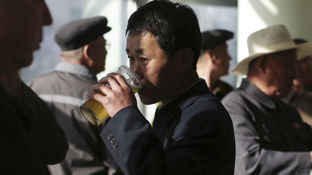Beer o'clock: North Korean men drink beer at the Taedonggang Beer shop in Pyongyang.