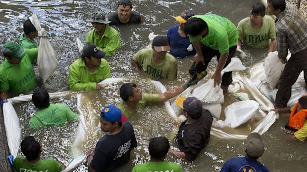 Workers build a dam from sandbags as they attempt to seal off a canal to search for remnants of the explosive device thrown into the canal on Tuesday.