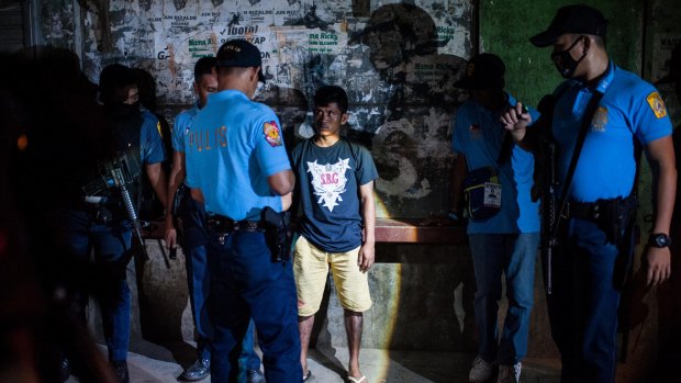 Police question a man during a night patrol at a shanty community on in Manila on the weekend.