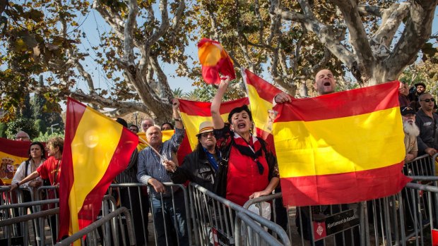 People wave Spanish flags as they protest outside the Parliament of Catalonia during a parliamentary session to pass the start of the independence process on Monday in Barcelona. 