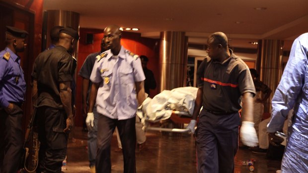 Mali security personnel remove the body of a victim from the Radisson Blu hotel after the attack that killed at least 21 people on Friday.
