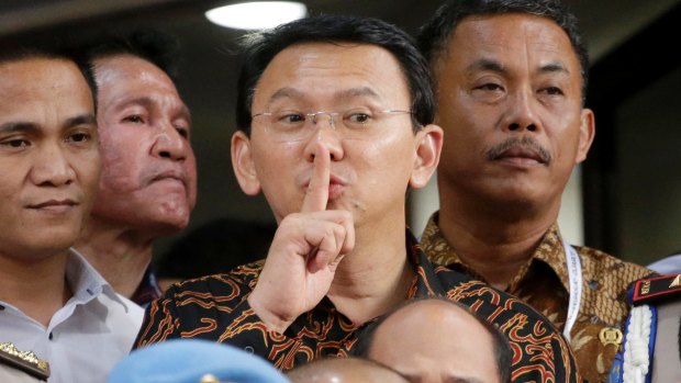 Jakarta Governor Basuki Tjahaja Purnama, popularly known as Ahok, centre, gestures to the media as he leaves after being questioned by investigators at the National Police Headquarters in Jakarta last month.