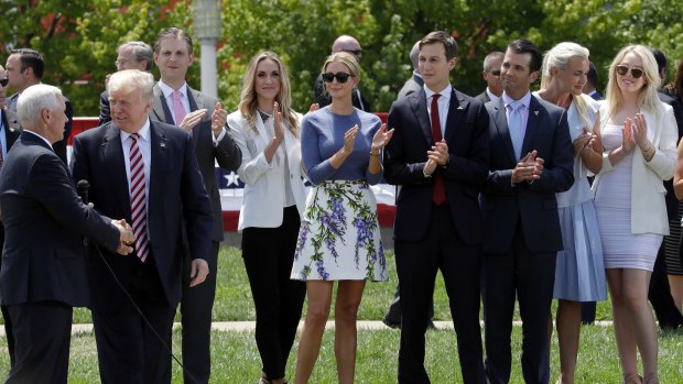 Donald Trump shakes now Vice-President Mike Pence's hands as his sons Eric, daughter-in-law Lara Yunaska, daughter Ivanka, Ivanka's husband Jarred Kushner, son Donald jnr and wife Vanessa, and daughter Tiffany look on during the campaign.