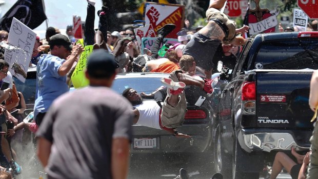 People fly as a vehicle drives into a group of protesters demonstrating against a white nationalist rally in Charlottesville, Virginia in August.