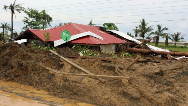 A house is buried in a mudslide brought on by heavy rains from tropical storm Jangmi, locally called Seniang, in Tanuan town, Samar province. 
