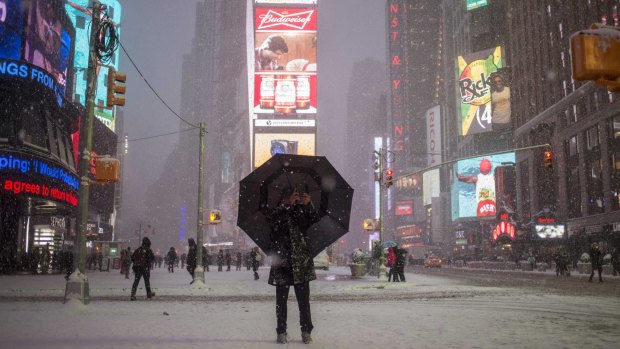 Historic storm: A man takes a photograph in Times Square.