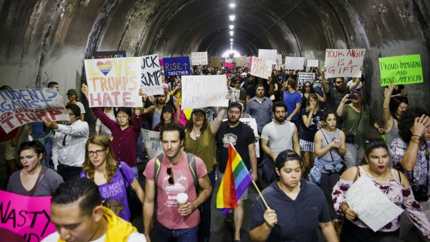 Demonstrators hold signs while marching through the Third Street tunnel during a protest in Los Angeles.