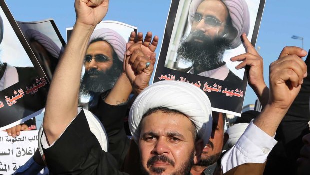 Iraqi Shiite protesters chant slogans against the Saudi government as they hold posters showing Sheikh Nimr al-Nimr in Najaf, south of Baghdad, Iraq.