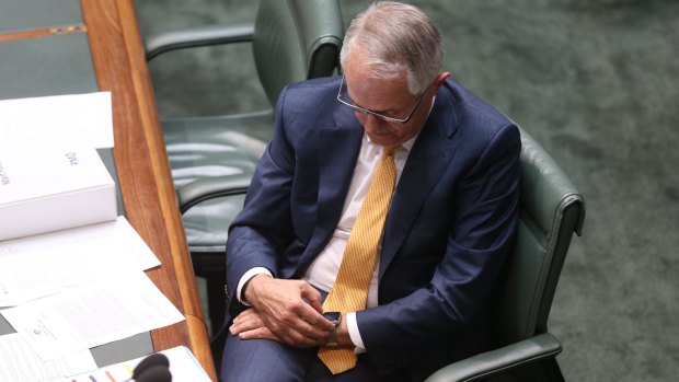 Prime Minister Malcolm Turnbull checks his Apple watch during question time.