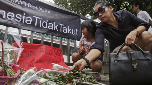 A woman lays flowers outside the Starbucks cafe after January's terrorist attack in Jakarta.