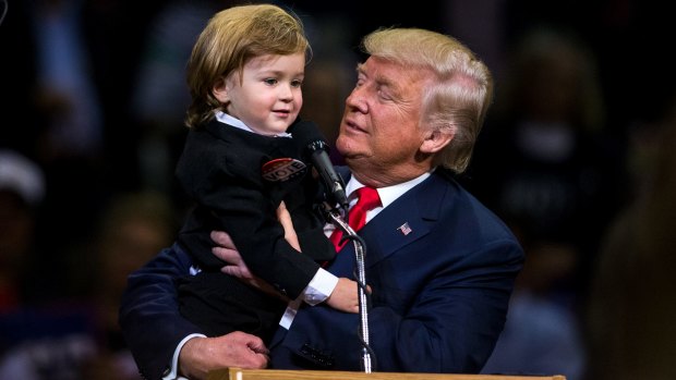 Mini-he: Donald Trump holds two-year-old Hunter Tirpak who is dressed as Trump.