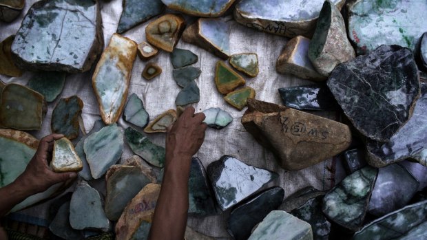 A Burmese jade dealer arranges his display at a market stall in Mandalay, Myanmar last year.