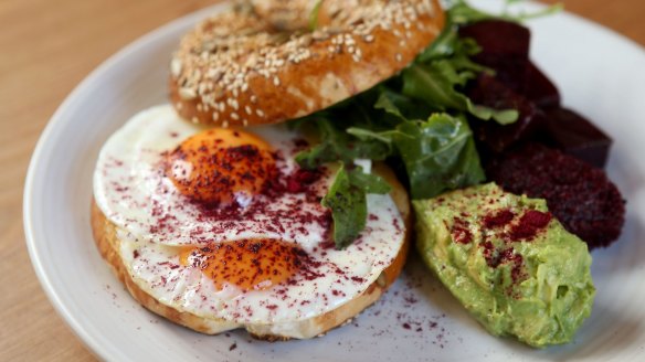 Gluten-free bagel with fried egg, sherry-roasted beetroot and smashed avocado.