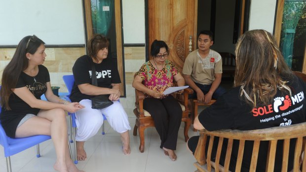 The widow and son of killed Bali police officer Wayan Sudarsa meet with representatives of Bali charity Solemen, who have raised more than $10,000 for the family via a crowdfunding campaign.