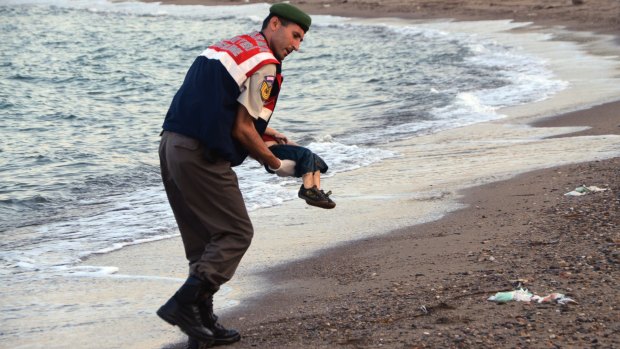 A paramilitary police officer carries the body of Aylan Kurdi near the Turkish resort of Bodrum.