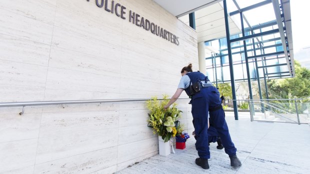 Police officers lay flowers at NSW Police State Crime Command in Parramatta where a boy gunned down Curtis Cheng, who worked for the police finance department.
