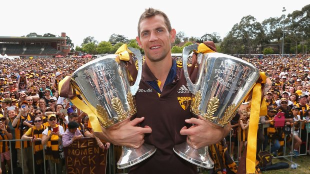 Luke Hodge with the club's past two premiership cups, a testament to a positive culture at Hawthorn.