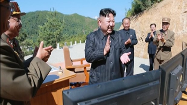 An unverified image taken from North Korean TV shows North Korean leader Kim Jung-un applauding the missile test.