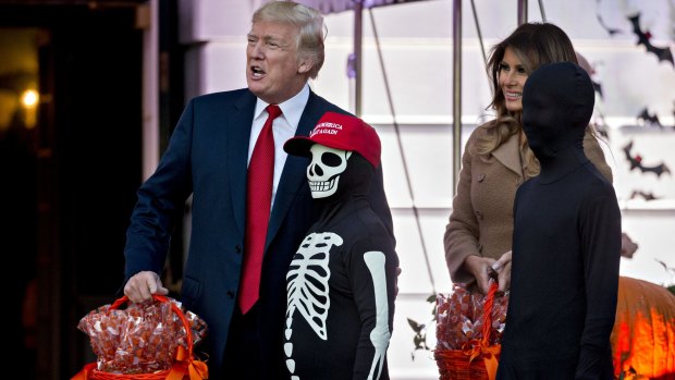 US President Donald Trump and First Lady Melania Trump celebrate Halloween with children in the White House on the same day as the Russia probe began claiming scalps. 