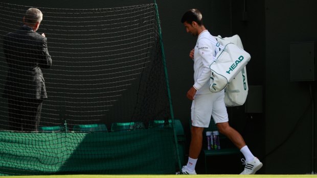 Novak Djokovic walks off at Wimbledon after his loss to Sam Querrey.
