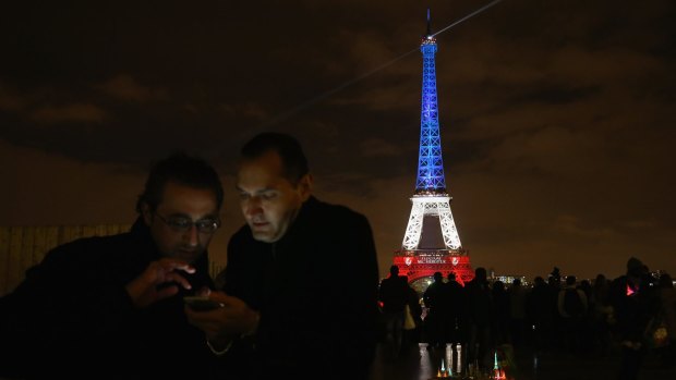 The Eiffel Tower is illuminated in the colours of the French flag, in honour of the victims of the attacks.