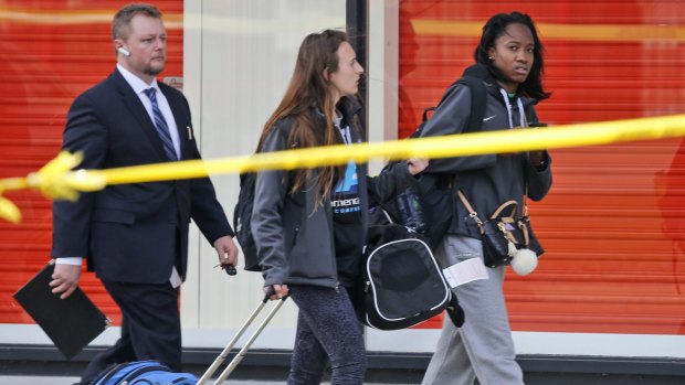 Two travelers are escorted by a Richmond police officer as they leave a Greyhound bus station on Thursday.
