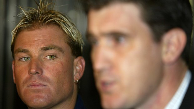 A pensive Shane Warne looks on as James Sutherland speaks to the press in Johannesburg, after the Australian spin bowler failed a drugs test at the 2003 Cricket World Cup.