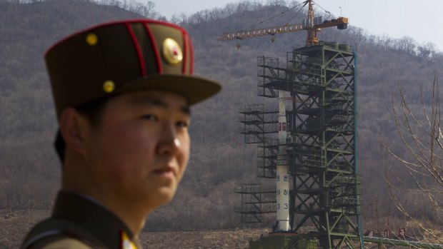 A North Korean soldier stands in front of the Unha 3 rocket at a launching site at Tongchang-ri, in 2012.