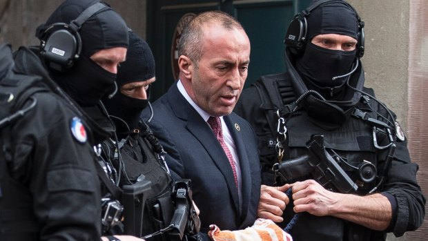 Former prime minister of Kosovo Ramush Haradinaj  leaves the court escorted by hooded police officers in Colmar, eastern France on  January 12.
