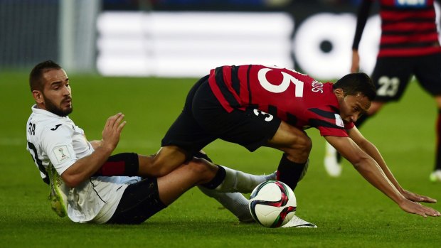 Stumbling: Wanderers forward Kearyn Baccus is tackled by Setif midfielder Toufik Zerara during the FIFA Club World Cup fifth place playoff at Marrakesh Stadium.