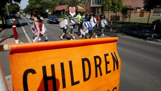 Children cross the road in a school zone. 